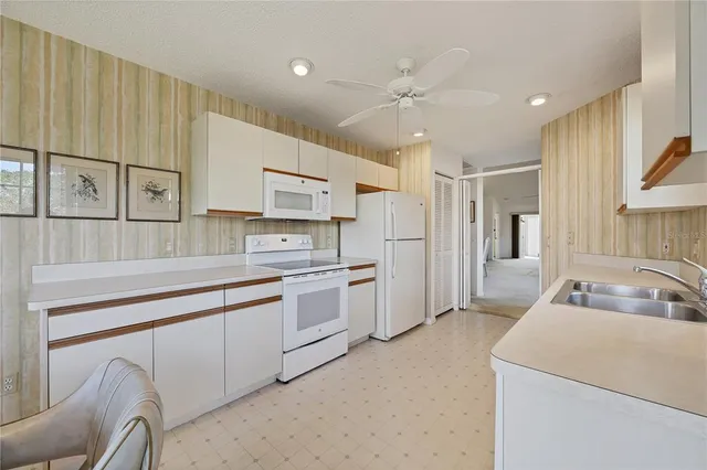 a sign board with a big yard and palm trees