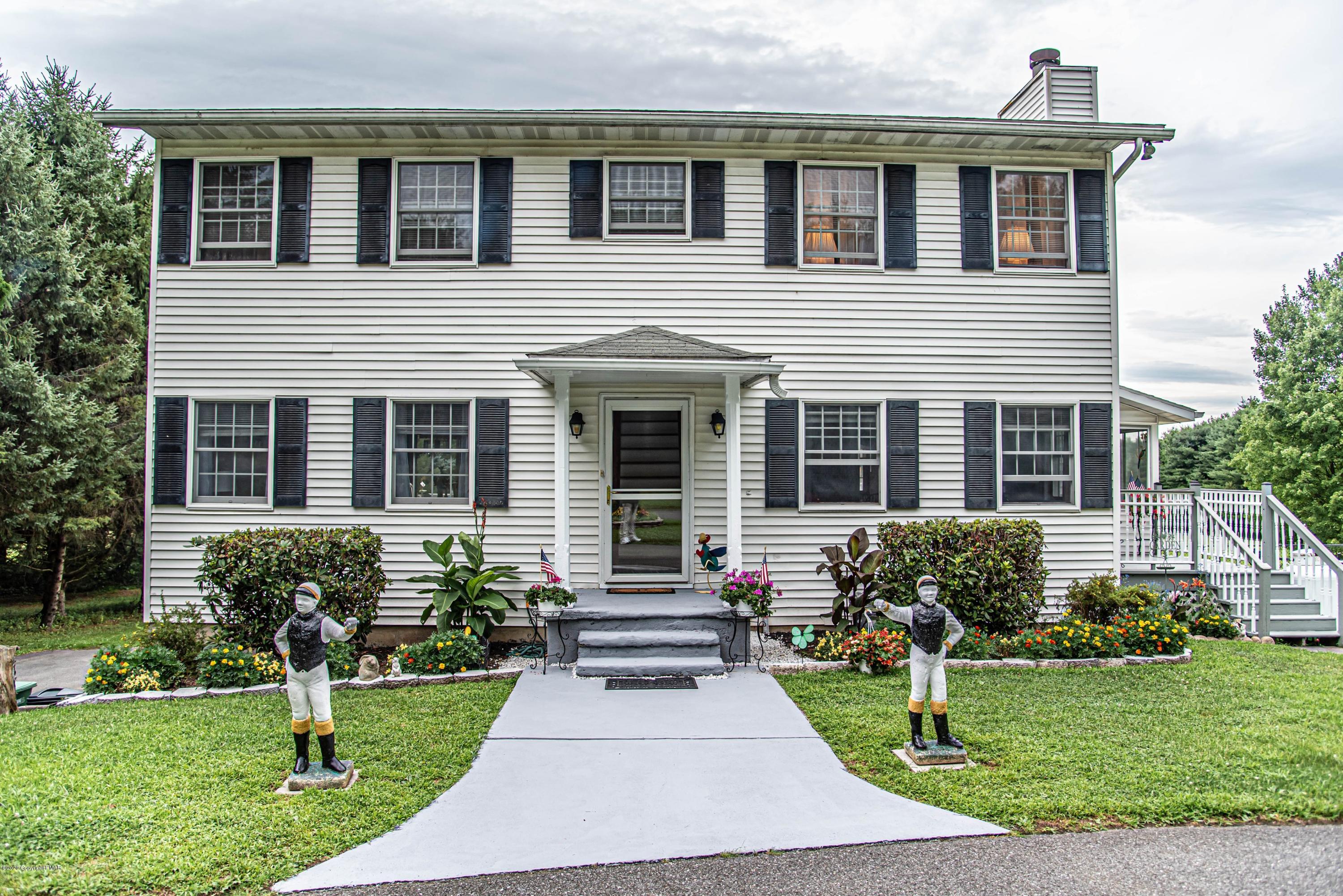 a front view of house with yard and green space