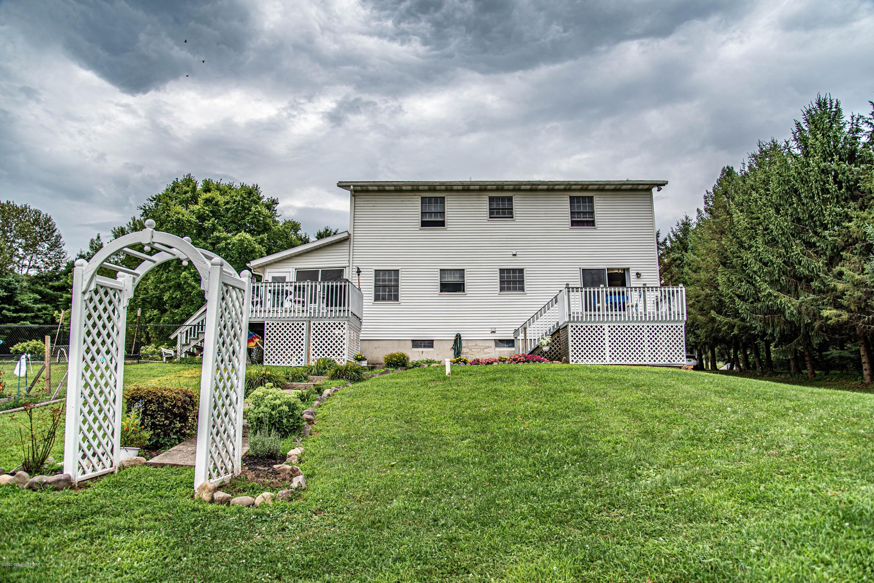 187 Old Stagecoach Road Gilbert, PA 18331 - Photo 21 of 31 a view of a white house with a big yard and potted plants