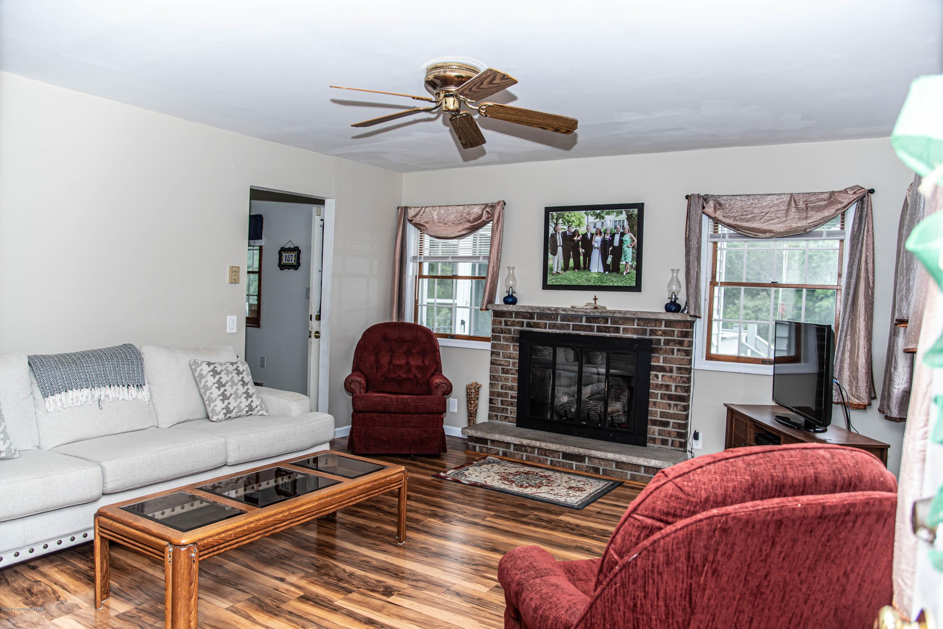 187 Old Stagecoach Road Gilbert, PA 18331 - Photo 7 of 31 a living room with furniture a fireplace and a large mirror