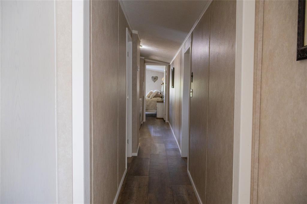 130 Firefly Drive Springtown, TX 76082 - Photo 11 of 25 a view of a hallway with wooden floor