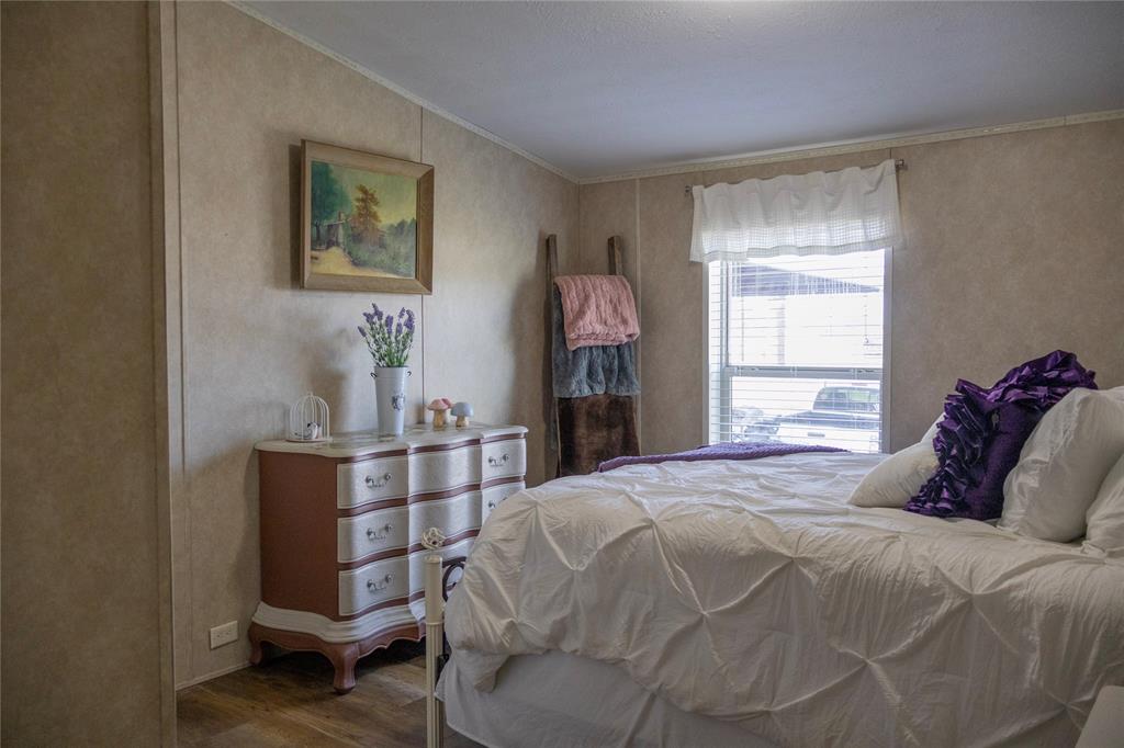 130 Firefly Drive Springtown, TX 76082 - Photo 12 of 25 a bedroom with a bed and wooden floor