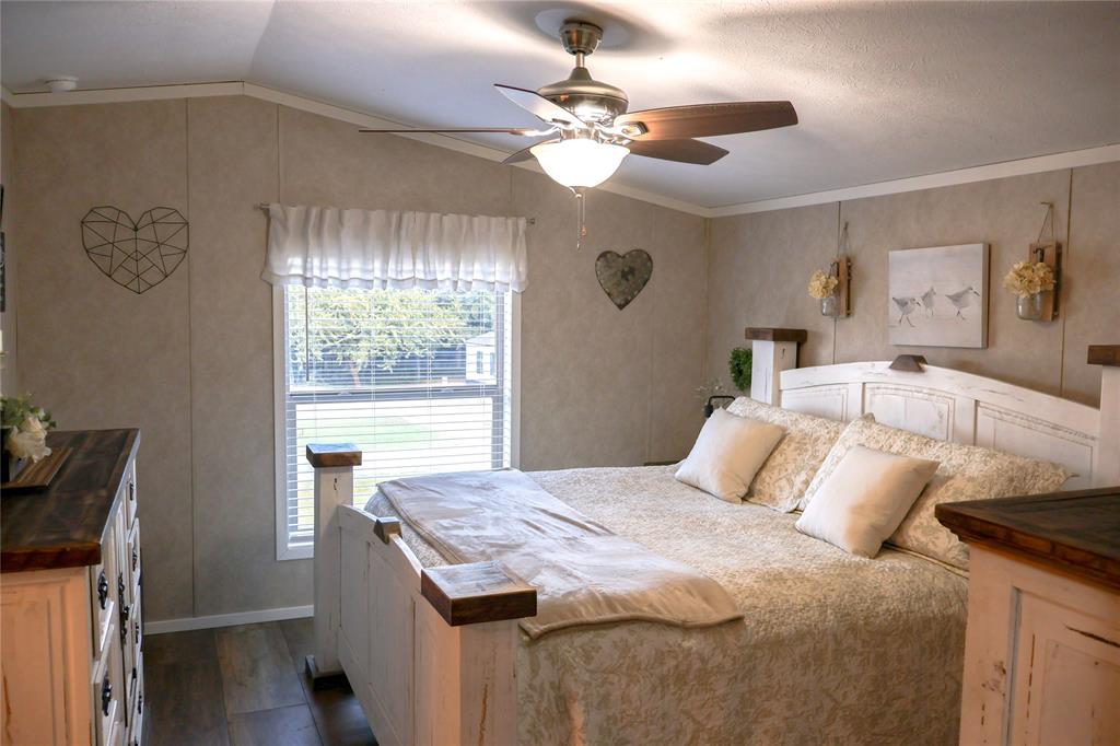 130 Firefly Drive Springtown, TX 76082 - Photo 16 of 25 a bedroom with a bed and a chandelier