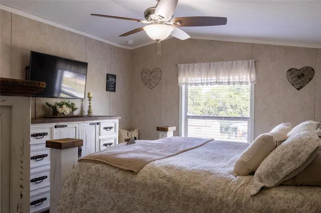 a bedroom with a bed and a flat tv screen on the dresser