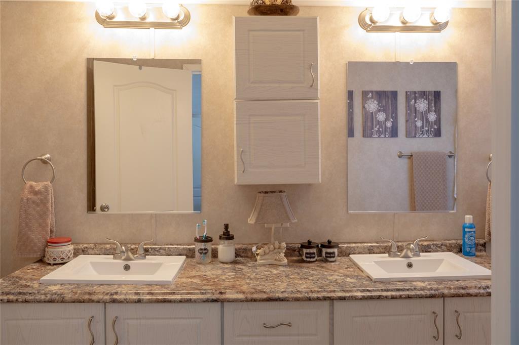 130 Firefly Drive Springtown, TX 76082 - Photo 18 of 25 a bathroom with a granite countertop sink and a mirror