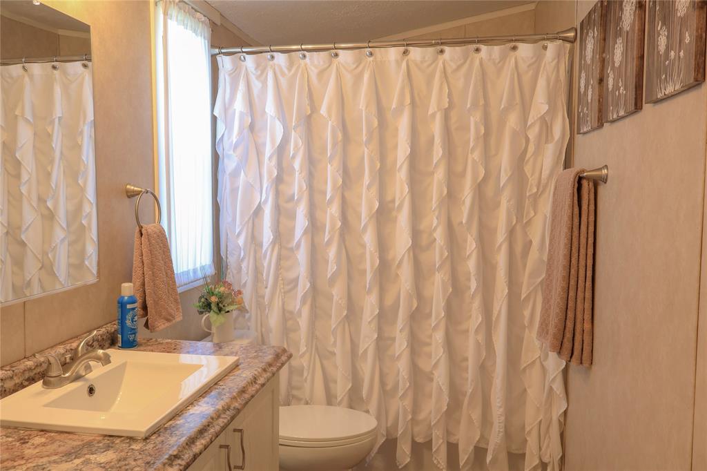 130 Firefly Drive Springtown, TX 76082 - Photo 19 of 25 a bathroom with a granite countertop sink and a mirror