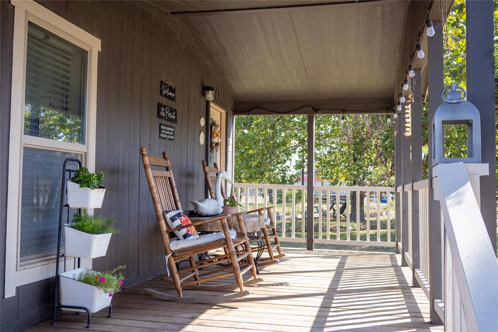 130 Firefly Drive Springtown, TX 76082 - Photo 4 of 25 a view of a patio with table and chairs potted plants with wooden floor