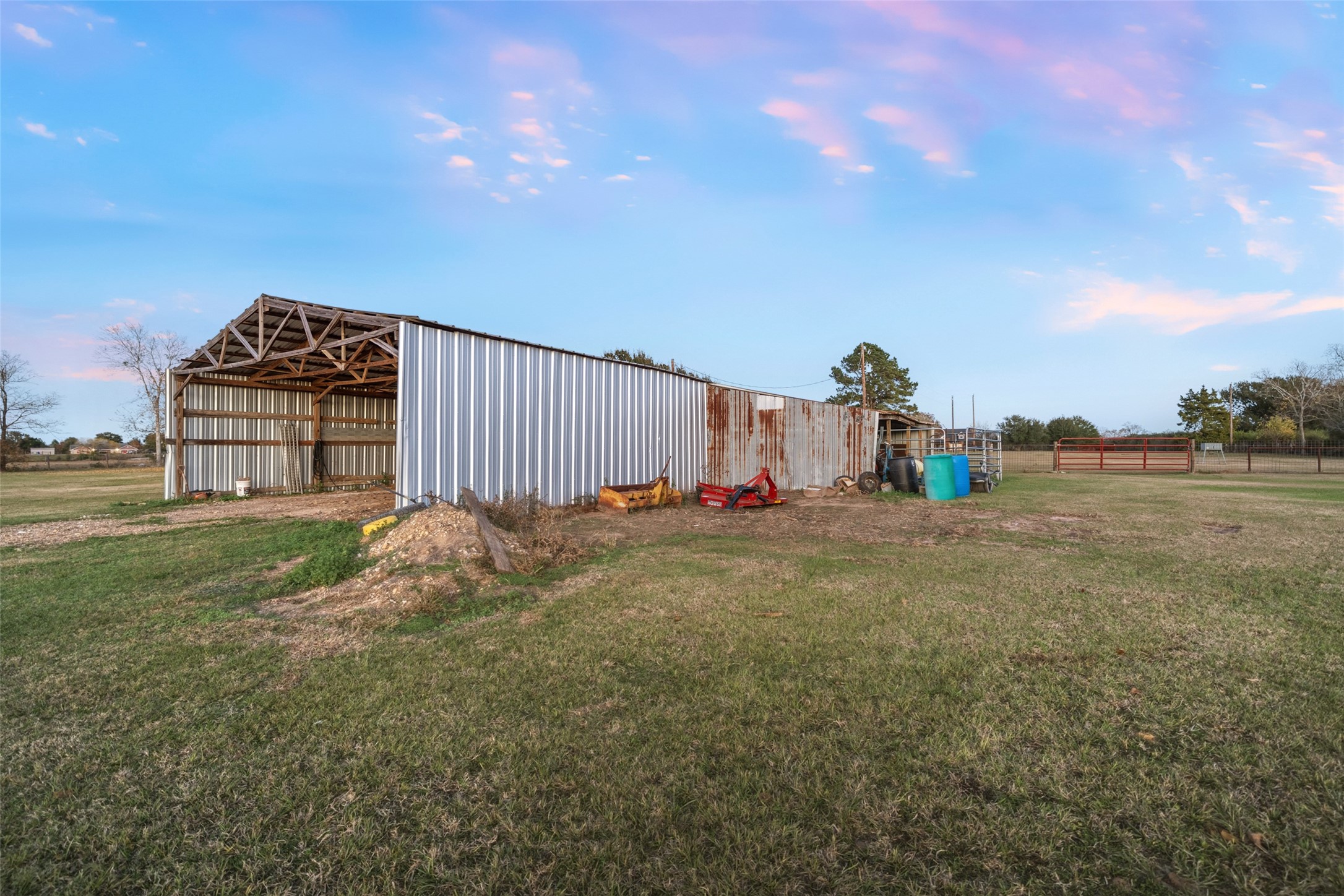 19989 Meadow Bend Road Hempstead, TX 77445 - Photo 12 of 35 Large barn and open shop areas feature concrete floors and lighting, offering practical workspace and equipment storage options.
