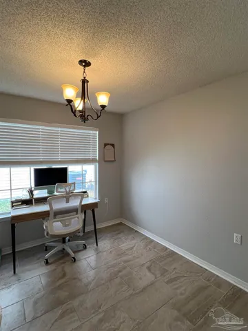 a view of a dining room with furniture and a chandelier