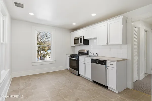 a kitchen with stainless steel appliances granite countertop a stove a sink and a microwave