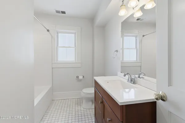 a bathroom with a sink a light fixture and a toilet