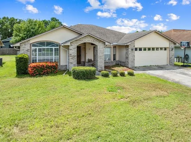 a view of a white house with a big yard and large trees