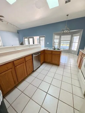 a kitchen with stainless steel appliances a sink a counter top space cabinets and a window