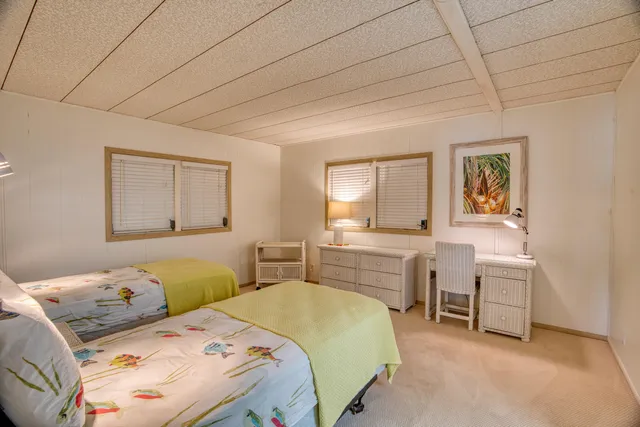 a bedroom with two beds and a lamp with window