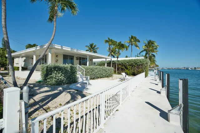 a view of a chair and table in backyard of the house