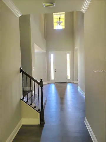 a view of a hallway with wooden floor and staircase