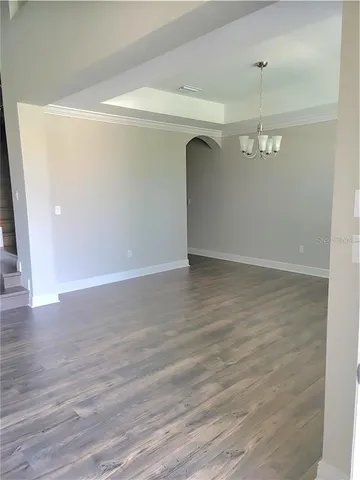 a view of a room with wooden floor and white walls