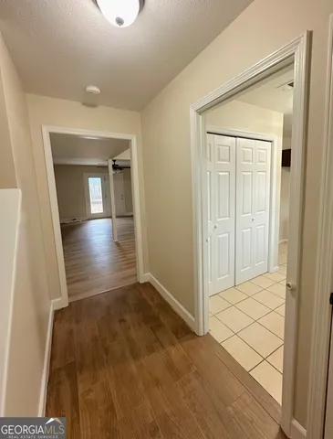 an empty room with wooden floor and cabinet