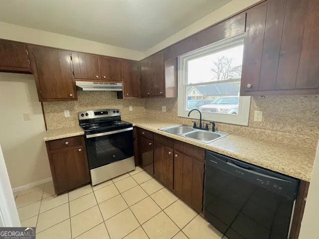 a kitchen with stainless steel appliances a sink stove and refrigerator