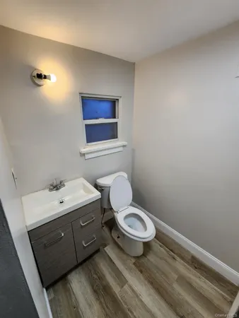 a bathroom with a toilet sink a mirror and vanity