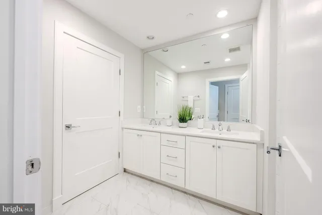 a spacious bathroom with a granite countertop sink a mirror and a
