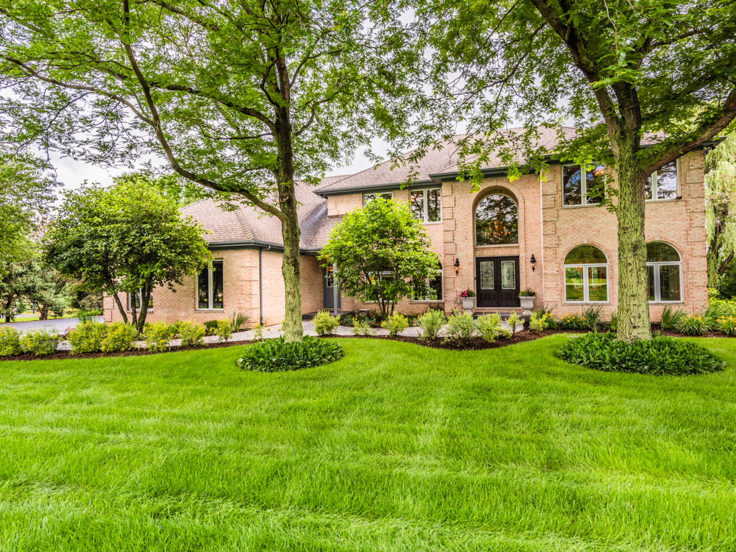 a view of a white house with a big yard and large tree