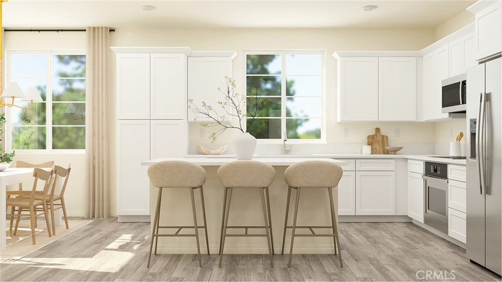 a kitchen with a table chairs refrigerator and cabinets