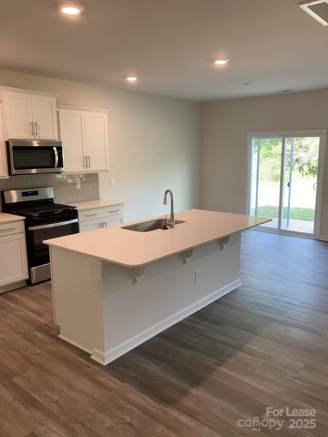 1834 Vanderlyn Street Monroe, NC 28112 - Photo 4 of 18 a kitchen with stainless steel appliances granite countertop a sink a stove and a wooden floors