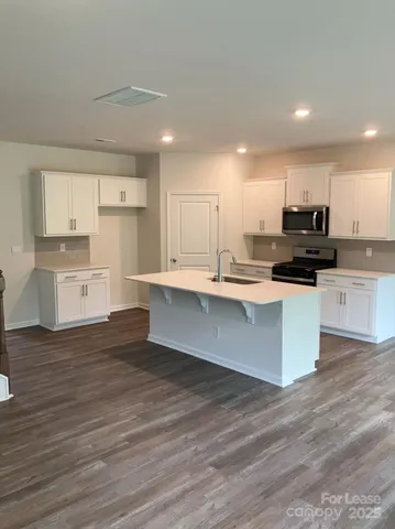 a large kitchen with cabinets and wooden floor