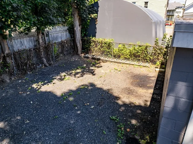 a view of a yard with wooden fence