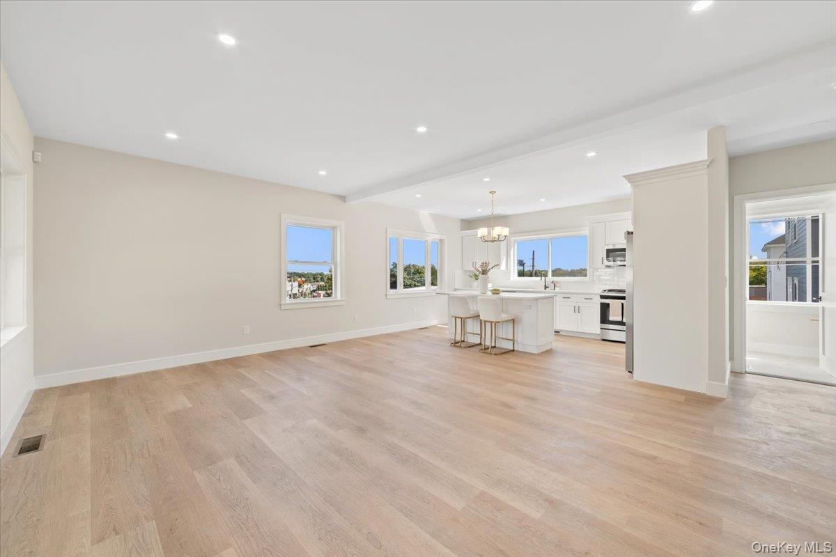 395 5th Avenue New Rochelle, NY 10801 - Photo 6 of 26 a view of a kitchen with wooden floor and a living room