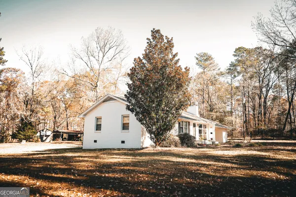 a view of a house with a yard and trees