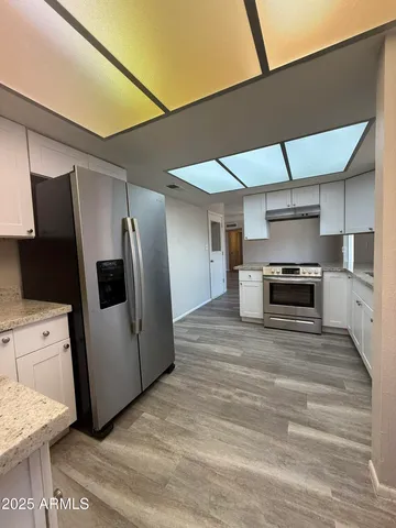 a large kitchen with a stove and a refrigerator