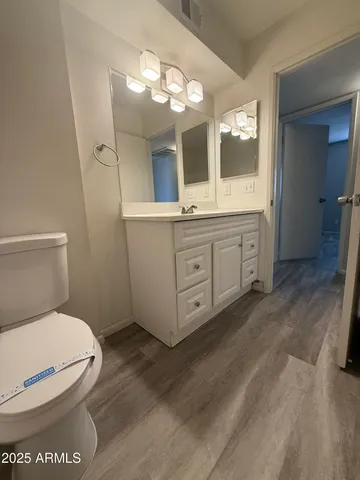 a spacious bathroom with a toilet sink and mirror