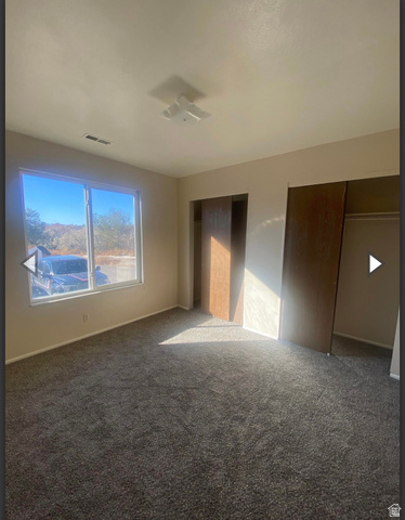 102 East Richelman Lane Wellington, UT 84542 - Photo 11 of 39 Unfurnished bedroom with carpet floors and multiple closets