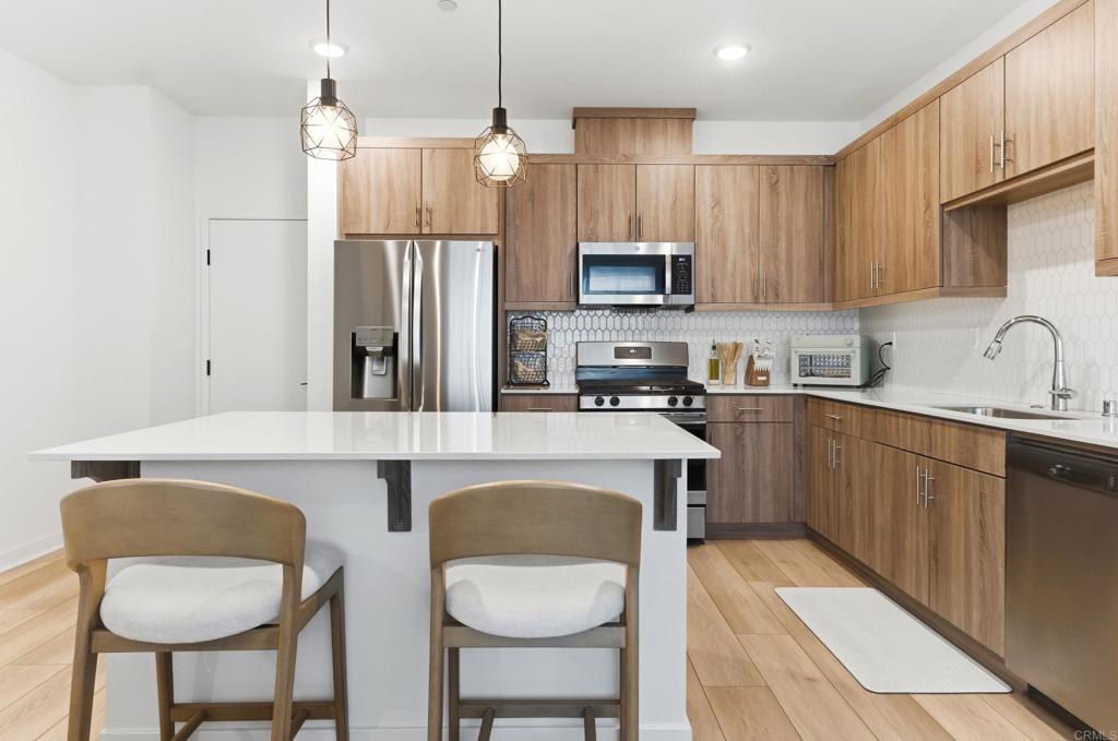 35172 Rangpur Lane Fallbrook, CA 92028 - Photo 2 of 47 a kitchen with stainless steel appliances a sink a stove a refrigerator cabinets and a center island