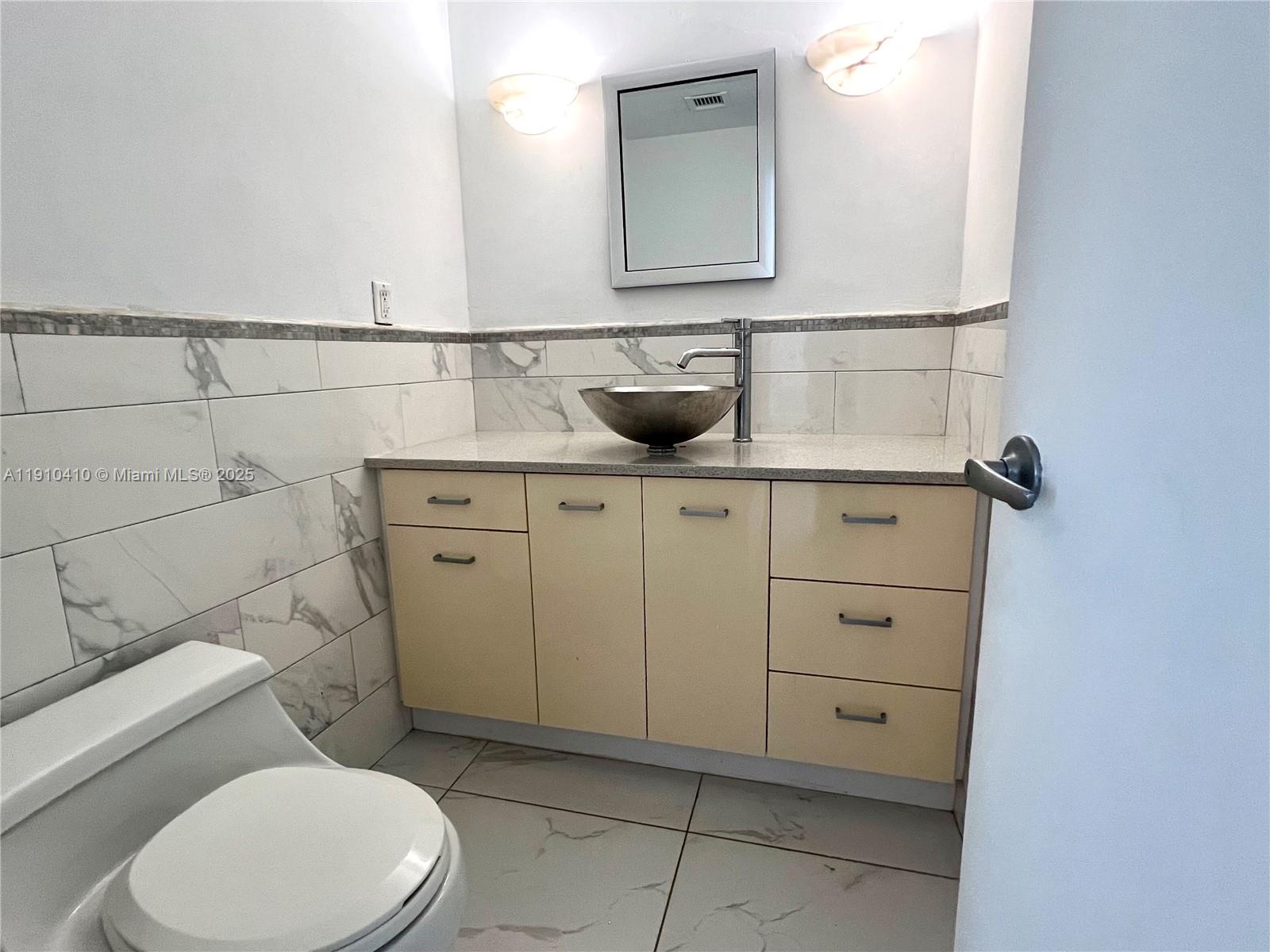 1865 79th Street Causeway, Unit 7I North Bay Village, FL 33141 - Photo 34 of 40 a bathroom with a toilet sink and mirror