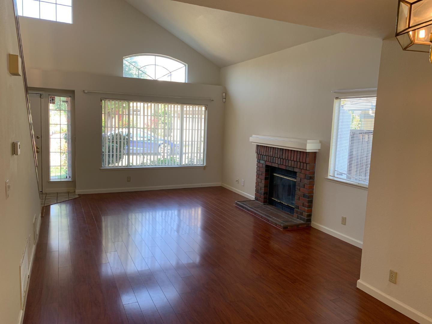 562 Costigan Circle Milpitas, CA 95035 - Photo 1 of 25 an empty room with wooden floor fireplace and windows