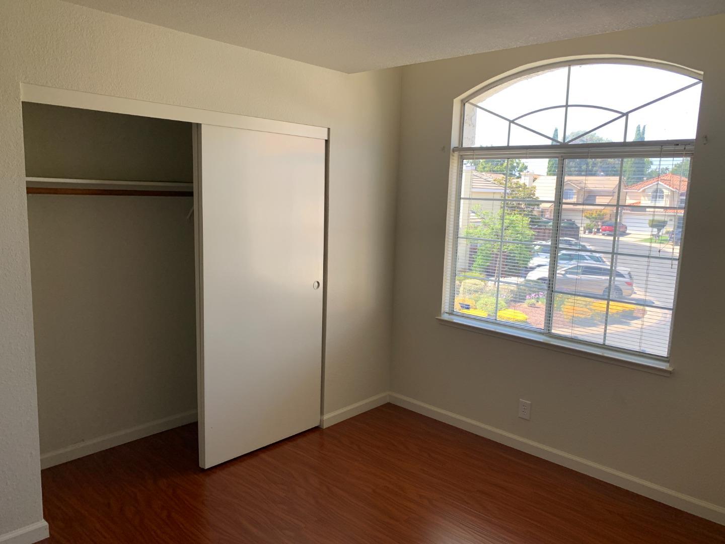 562 Costigan Circle Milpitas, CA 95035 - Photo 11 of 25 an empty room with wooden floor and windows
