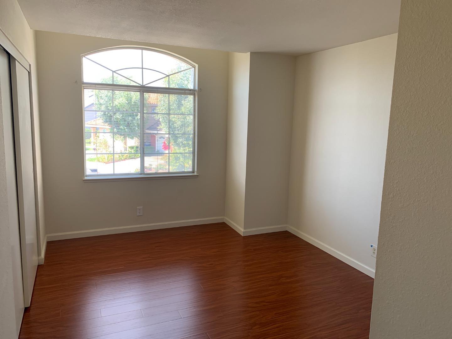 562 Costigan Circle Milpitas, CA 95035 - Photo 13 of 25 an empty room with wooden floor and windows