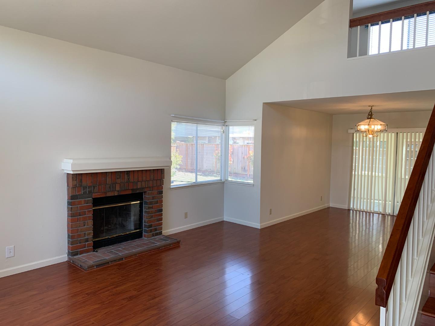 562 Costigan Circle Milpitas, CA 95035 - Photo 2 of 25 an empty room with wooden floor fireplace and windows
