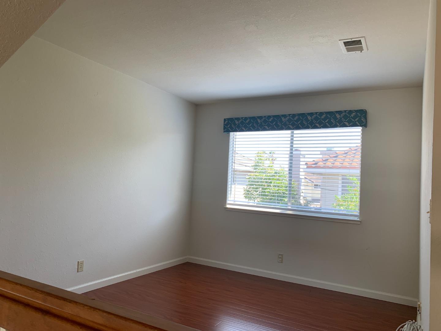 562 Costigan Circle Milpitas, CA 95035 - Photo 22 of 25 a view of an empty room with wooden floor and a window