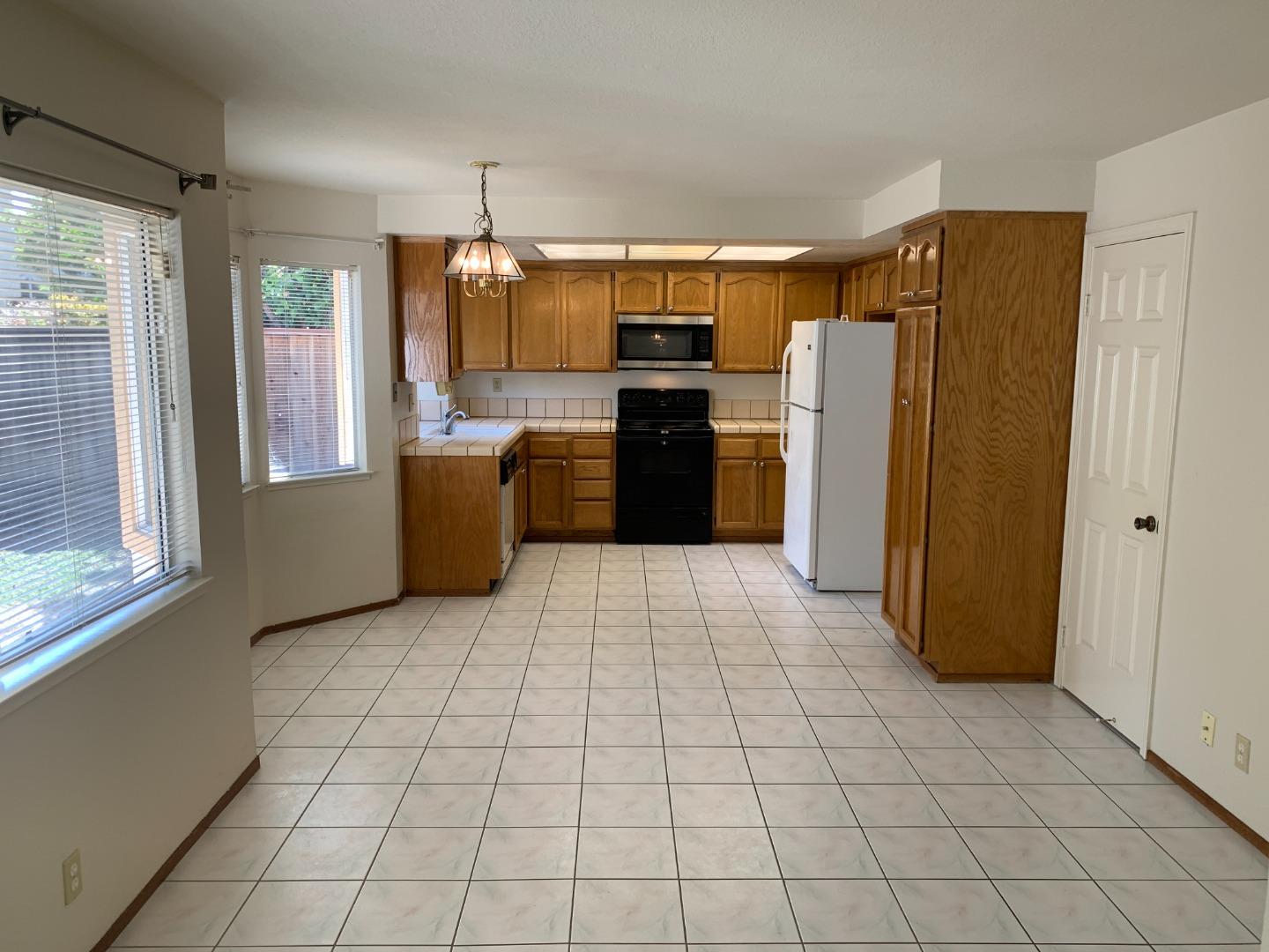 562 Costigan Circle Milpitas, CA 95035 - Photo 7 of 25 a kitchen with stainless steel appliances granite countertop a refrigerator and a stove top oven