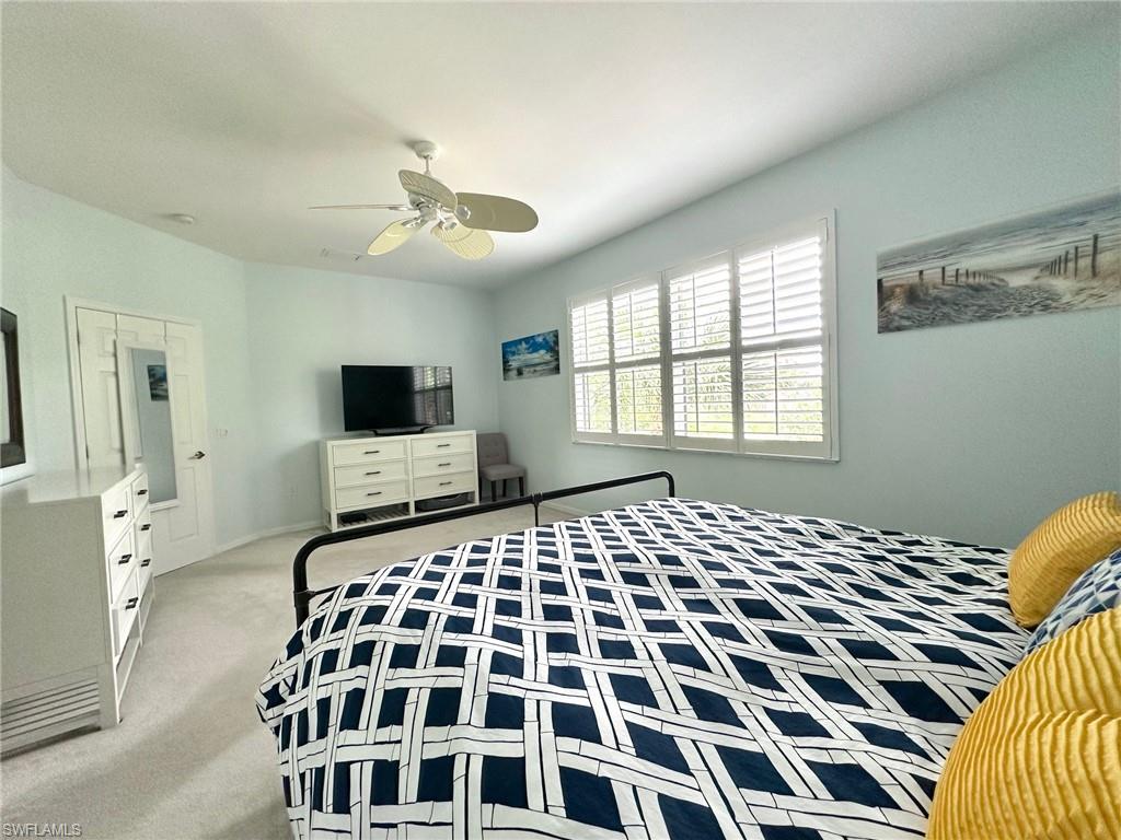 12259 Toscana Way, Unit 202 Bonita Springs, FL 34135 - Photo 19 of 40 a bedroom with a large bed and a flat tv screen