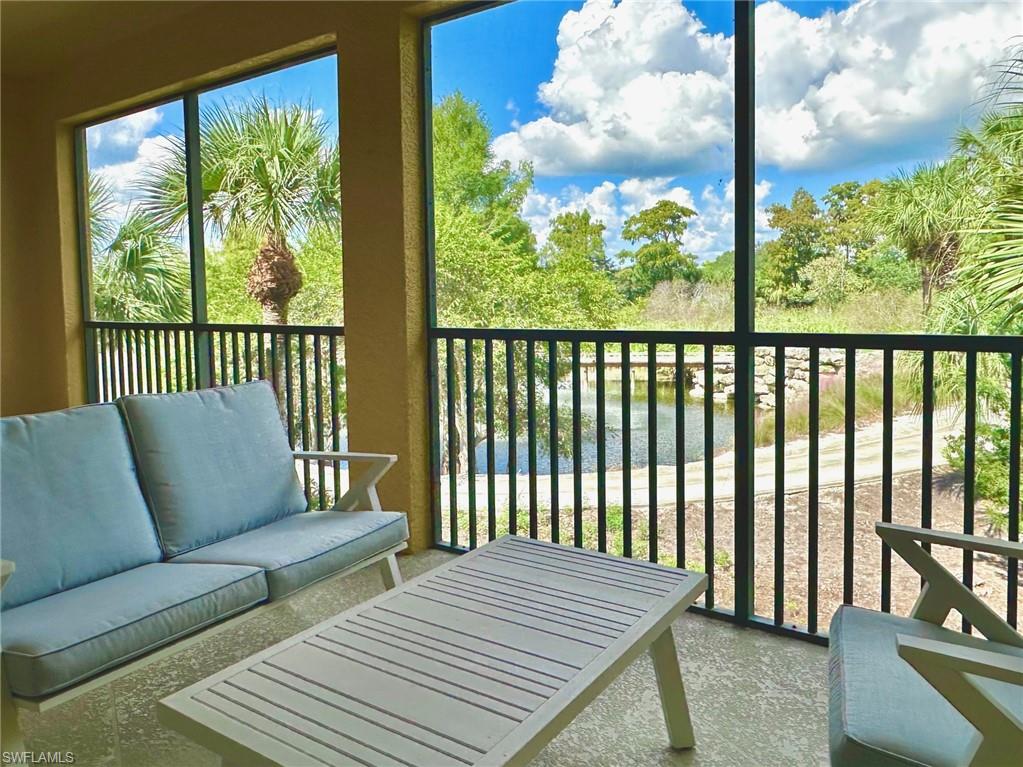 12259 Toscana Way, Unit 202 Bonita Springs, FL 34135 - Photo 24 of 40 a balcony with wooden floor table and chairs