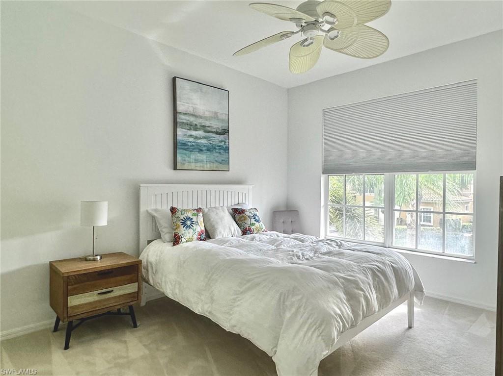 12259 Toscana Way, Unit 202 Bonita Springs, FL 34135 - Photo 28 of 40 a bedroom with a bed and a chandelier