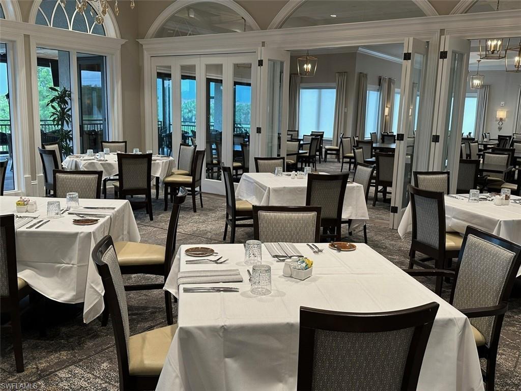 12259 Toscana Way, Unit 202 Bonita Springs, FL 34135 - Photo 33 of 40 a view of a dining room with furniture window and wooden floor