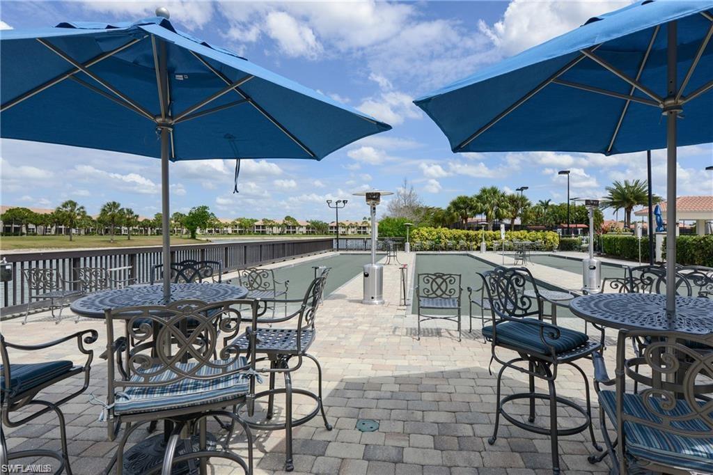 12259 Toscana Way, Unit 202 Bonita Springs, FL 34135 - Photo 37 of 40 a view of a patio with furniture and umbrella