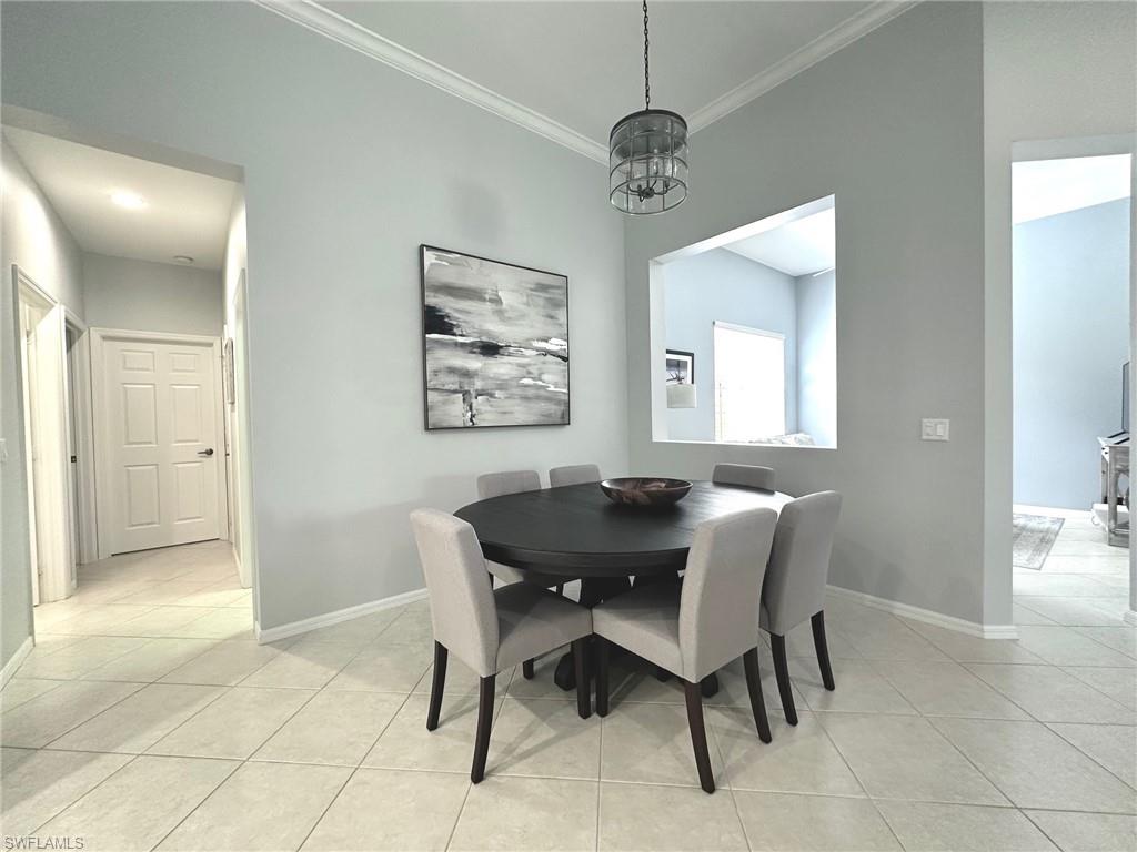 12259 Toscana Way, Unit 202 Bonita Springs, FL 34135 - Photo 6 of 40 a view of a dining room with furniture and chandelier