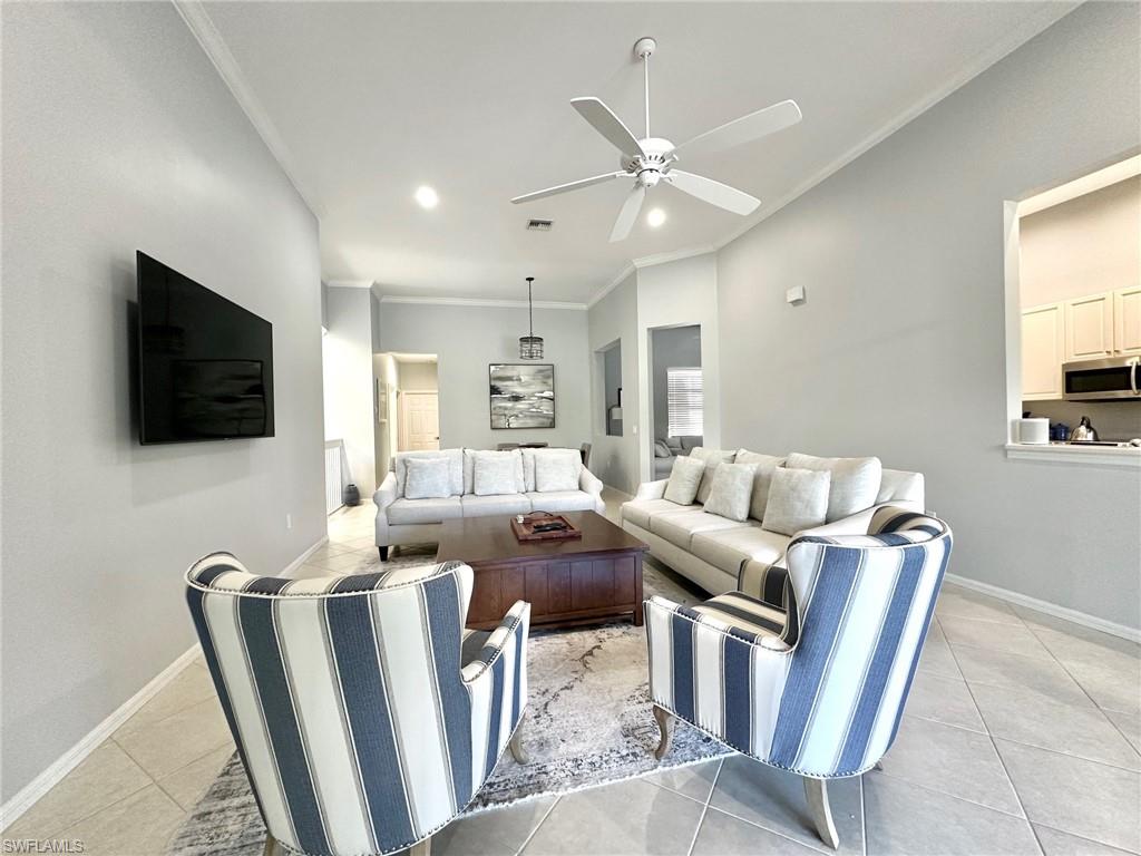 12259 Toscana Way, Unit 202 Bonita Springs, FL 34135 - Photo 7 of 40 a living room with furniture a flat screen tv and a window